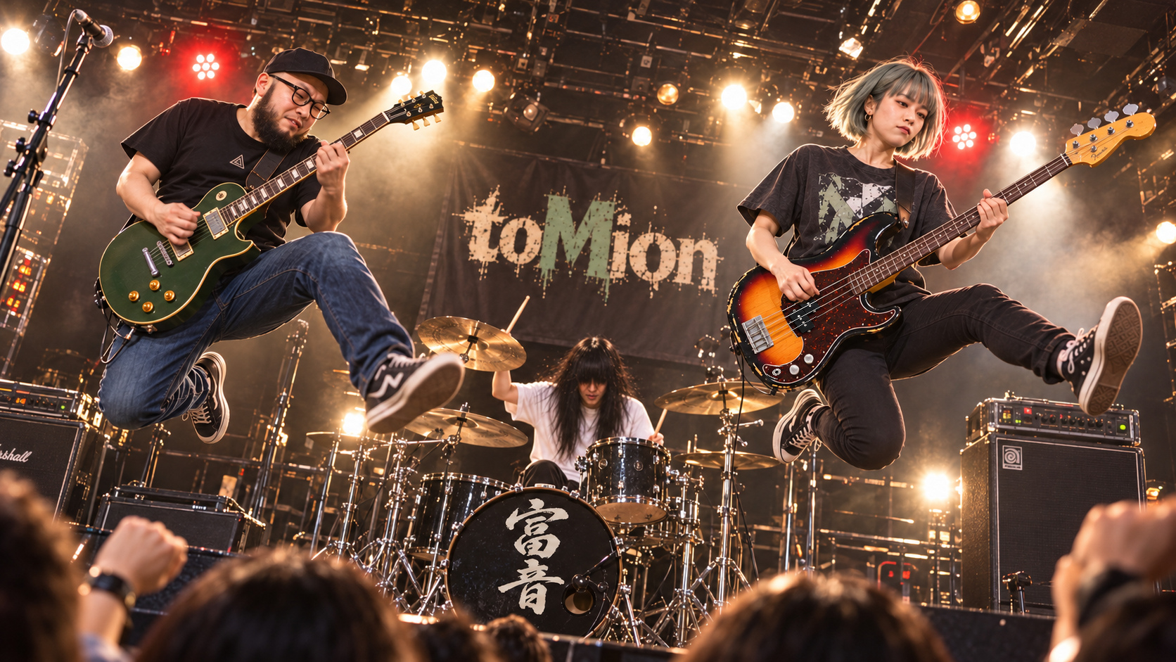 ライブハウスでジャンプするtoMion。左にギターのtomio、中央奥にドラムのryo、右にメインボーカル・ベースのMion。